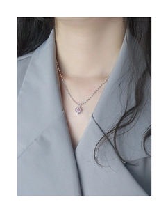 Gros plan d'un collier cœur en argent S925 avec zircon rose porté par un mannequin