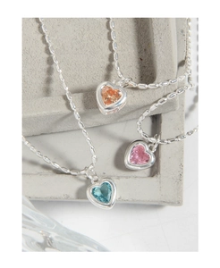 Gros plan de pendentifs en forme de cœur en zircon bleu ciel, rose cerise et orange