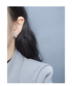 Close-up of minimalist S925 silver stud earrings with staggered pavé cubic zirconia