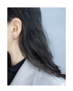 Detail of S925 silver hoop earrings with wavy texture on model in minimalist style