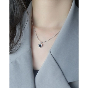 Collier cœur minimaliste en argent S925 avec pendentif noir porté par un mannequin