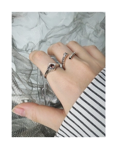 Detailed view of silver open rings featuring vertical textures and a centered garnet stone