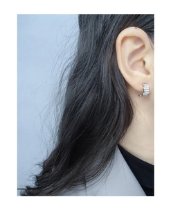Macro detail of S925 silver staggered zircon earrings on a model showing modern design