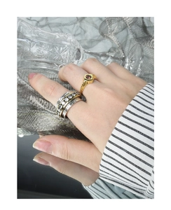 Detail of layered gold and silver rings with cubic zirconia and red gemstone on a model