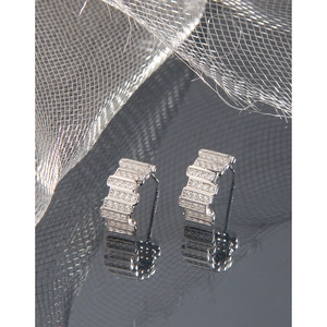 Minimalist S925 silver stud earrings with staggered zircon stones on black mirror surface