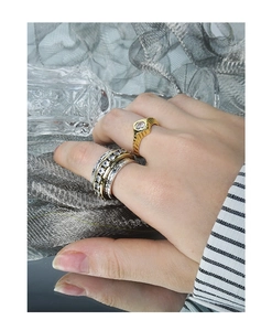 Detailed view of layered geometric rings with micro-set zircons on a model's hand