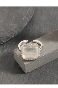Macro detail of S925 silver ring featuring a large rectangular gemstone on stone texture