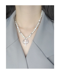 Gros plan du collier en argent S925 avec perles blanches et pendentif croix en zircon sur un mannequin
