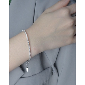Elegant S925 sterling silver tennis bracelet with sparkling zircons on a gray suit sleeve