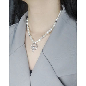 Collier de perles en argent S925 avec pendentif croix et zircon sur une veste grise