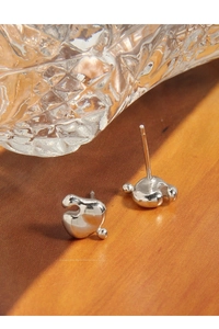 Macro shot of S925 silver stud earrings with liquid geometric design on wood surface