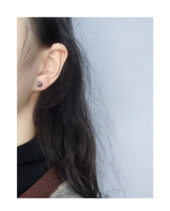 Close-up of vintage silver abstract heart earring worn on ear for minimalist style