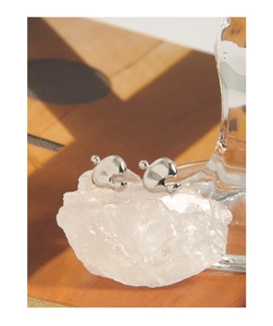Close-up of S925 sterling silver leaf stud earrings on a white crystal stone