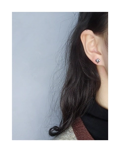 Close-up of minimalist silver apple stud earrings on a model for s925 jewelry display