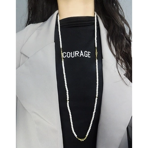 Elegant long S925 silver necklace with white pearls over a black turtleneck top