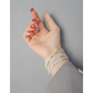 Elegant multi-layer white pearl wrap bracelet with gold beads for women on wrist