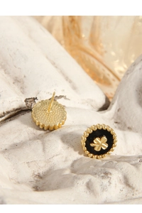 Macro view of gold S925 silver four-leaf clover stud earrings with black inlay detailing