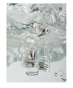 Macro shot of 925 silver heart drop earrings with high-polished mirror finish