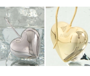 Macro shot of S925 sterling silver puffed heart earrings in polished gold and silver finish