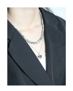 Detailed layered necklace featuring spotted stone beads and a polished silver heart pendant