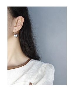 Close-up of S925 sterling silver heart-shaped drop earring on a model's ear