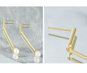 Detail view of gold bar earrings with pearls showing the S925 hallmark on silver post