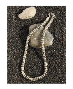Macro detail of dalmatian jasper stone beads on a necklace with silver clasp and chain