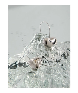 Polished S925 sterling silver heart earrings on ice-like display with macro detail