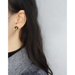 S925 silver clover stud earrings with black enamel and gold beaded edges on ear