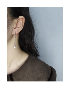 Close-up of minimalist S925 silver linear drop earrings with white pearl on model ear