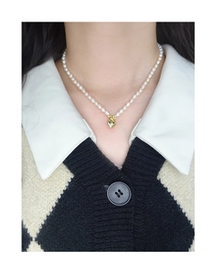 Close-up of S925 silver heart pendant necklace with elegant white pearls on a model