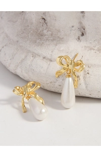 Detail of gold bow earrings with elegant white teardrop pearls and S925 silver posts