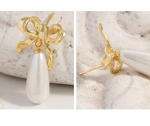 Macro detail of S925 sterling silver stamp on golden bow knot pearl drop earrings