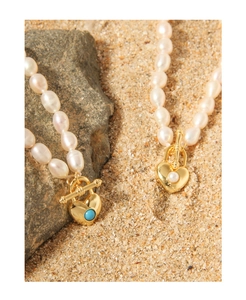 Detail of S925 silver pearl necklaces with golden heart pendants and OT toggle clasp