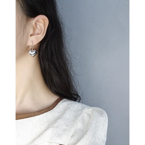 Minimalist S925 sterling silver puffed heart dangle earrings on model for a trendy look