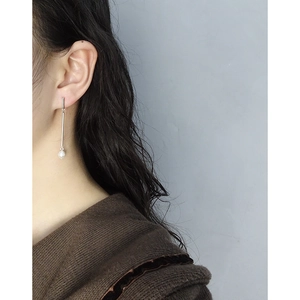 Minimalist S925 silver long drop pearl earrings worn by a model in a side profile view