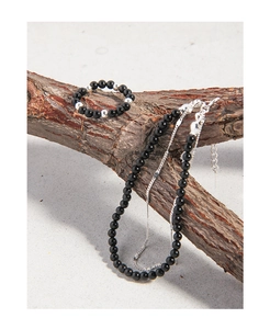 Détail de l'ensemble bracelet et bague en jade noir sur décor de branche naturelle