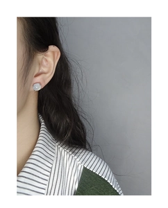 Close-up of elegant light grey jade stud earring on female model with silver setting