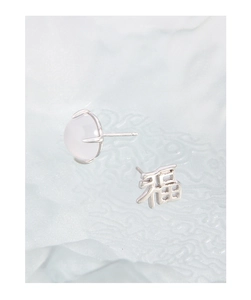 Detail of S925 silver stud earrings featuring a Fu character and translucent gemstone