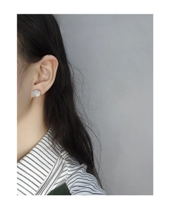 Detailed close-up of a minimalist S925 silver earring with a round white translucent stone
