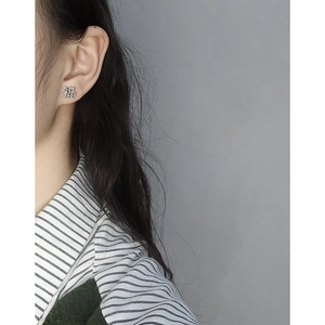 Minimalist S925 sterling silver Fu character stud earring worn on model's ear