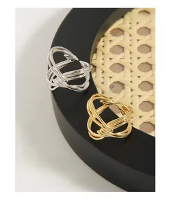 Dettaglio di anelli in argento S925 con design a nodo intrecciato in oro e argento