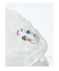 Gros plan d'une bague en argent S925 avec des pierres de zircon colorées en cœur