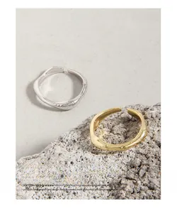 Detail shot of matte irregular fluid texture and S925 silver stamp on open rings