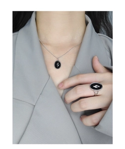 Detailed look at the silver tulip relief on black agate necklace and ring set