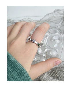 Gros plan sur une bague en argent S925 avec zircons et émeraudes en forme de cœur