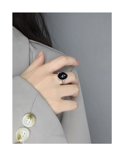 Detail of vintage S925 silver tulip black agate ring worn on model with grey suit
