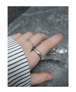 Close-up of S925 silver rings with matte lava texture on woman holding a glass