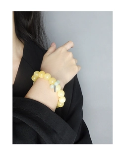 Detail of S925 silver yellow topaz bracelet with green jade bead on model's wrist