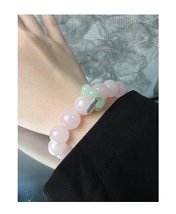 Detailed close-up of S925 sterling silver tag on pink agate and topaz beaded bracelet